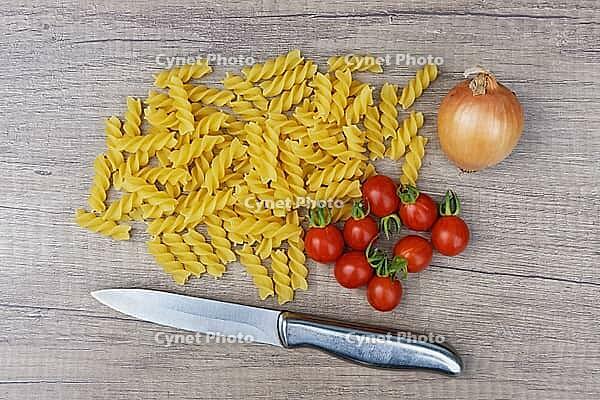 Onions (Allium cepa) with cocktail tomatoes (Solanum lycopersicum) and fusilli pasta, Kempen, North Rhine-Westphalia, Germany [IBR124629094]