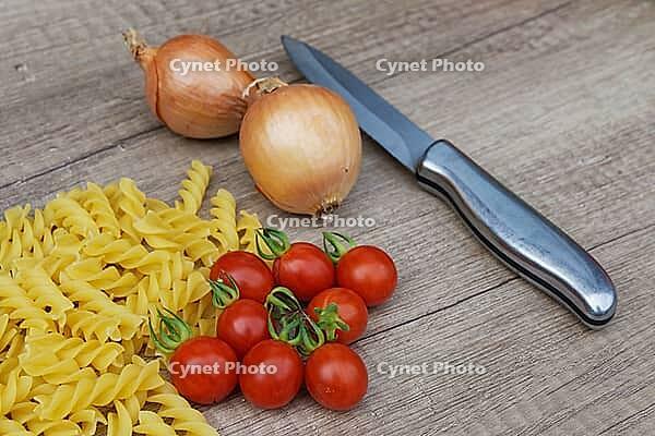 Onions (Allium cepa) with cocktail tomatoes (Solanum lycopersicum) and fusilli pasta, Kempen, North Rhine-Westphalia, Germany [IBR124629096]