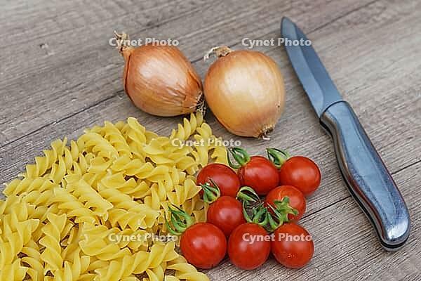 Onions (Allium cepa) with cocktail tomatoes (Solanum lycopersicum) and fusilli pasta, Kempen, North Rhine-Westphalia, Germany [IBR124629098]