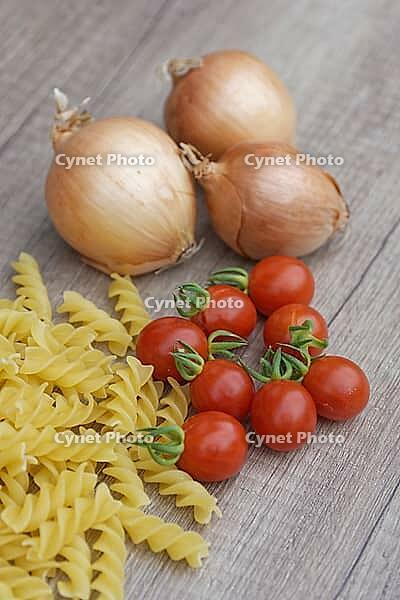Onions (Allium cepa) with cocktail tomatoes (Solanum lycopersicum) and fusilli pasta, Kempen, North Rhine-Westphalia, Germany [IBR124629101]