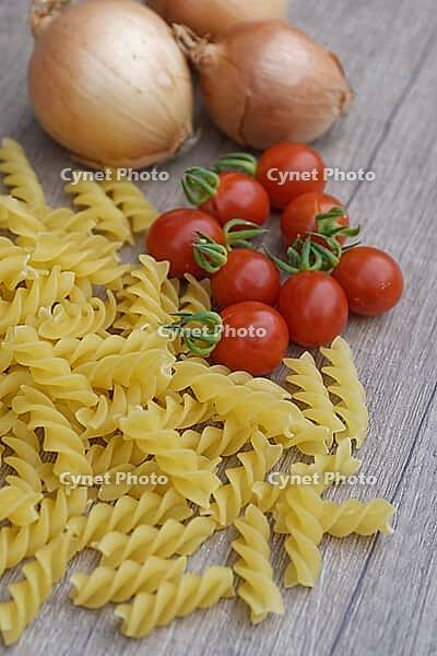 Onions (Allium cepa) with cocktail tomatoes (Solanum lycopersicum) and fusilli pasta, Kempen, North Rhine-Westphalia, Germany [IBR124629103]