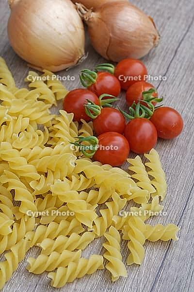 Onions (Allium cepa) with cocktail tomatoes (Solanum lycopersicum) and fusilli pasta, Kempen, North Rhine-Westphalia, Germany [IBR124629105]