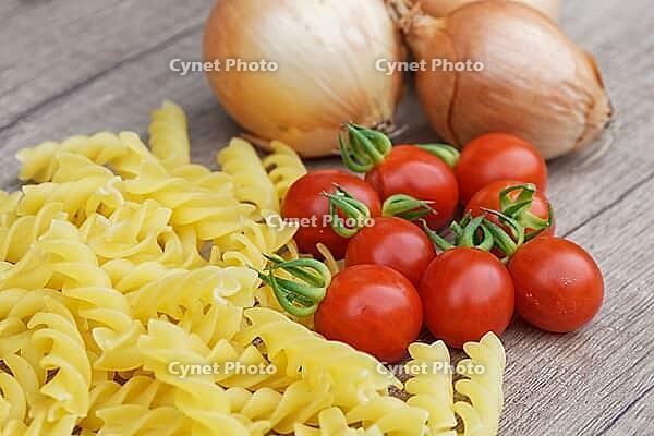 Onions (Allium cepa) with cocktail tomatoes (Solanum lycopersicum) and fusilli pasta, Kempen, North Rhine-Westphalia, Germany [IBR124629106]
