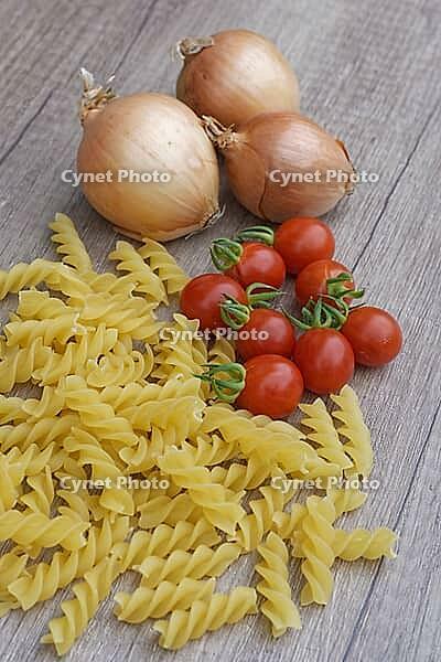 Onions (Allium cepa) with cocktail tomatoes (Solanum lycopersicum) and fusilli pasta, Kempen, North Rhine-Westphalia, Germany [IBR124629107]