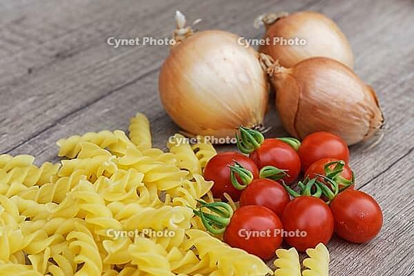 Onions (Allium cepa) with cocktail tomatoes (Solanum lycopersicum) and fusilli pasta, Kempen, North Rhine-Westphalia, Germany [IBR124629108]