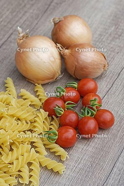Onions (Allium cepa) with cocktail tomatoes (Solanum lycopersicum) and fusilli pasta, Kempen, North Rhine-Westphalia, Germany [IBR124629112]