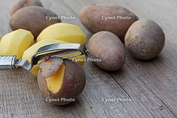 Peeled and unpeeled Laura potatoes with potato peeler, Kempen, North Rhine-Westphalia, Germany [IBR124629545]