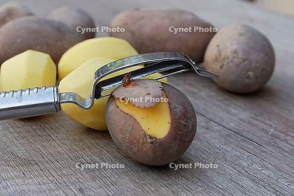 Peeled and unpeeled Laura potatoes with potato peeler, Kempen, North Rhine-Westphalia, Germany [IBR124629546]