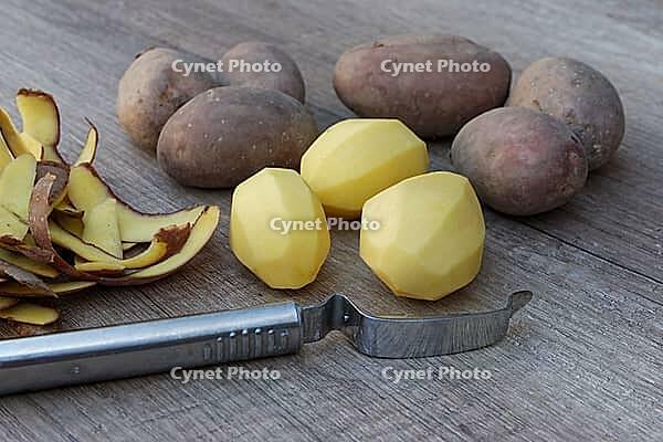 Peeled and unpeeled Laura potatoes with potato peeler, Kempen, North Rhine-Westphalia, Germany [IBR124629548]