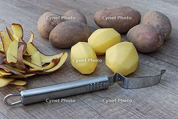 Peeled and unpeeled Laura potatoes with potato peeler, Kempen, North Rhine-Westphalia, Germany [IBR124629557]