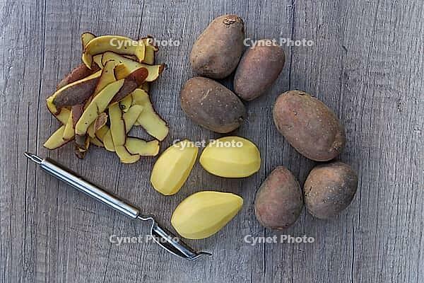 Peeled and unpeeled Laura potatoes with potato peeler, Kempen, North Rhine-Westphalia, Germany [IBR124629565]
