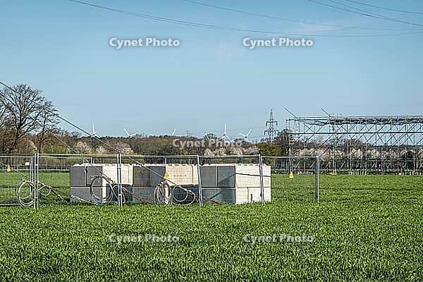 Counterweights for power line construction with wind turbines and cable bridge in the background, Hoya, Lower Saxony, Germany [IBR124631253]