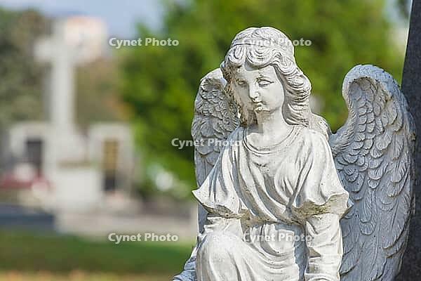 Sculpture of a little angel on a tomb in cemetery. Graz, Austria [IBR124636285]