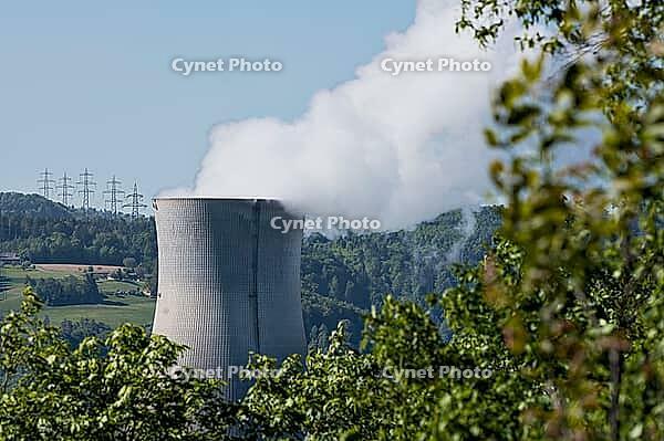 Nuclear power plant in Leibstadt with cooling tower and steam clouds, steam clouds over the nuclear power plant cooling turn, energy generation plant with nuclear power plant, nuclear power plant cooling tower between trees with steam clouds and power pol [IBR124636291]