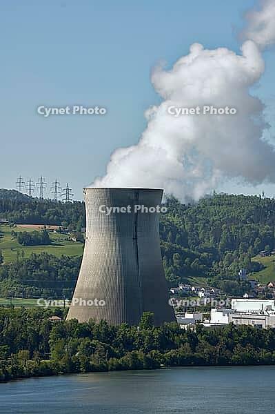 Nuclear power plant in Leibstadt with cooling tower and steam clouds, steam clouds over the nuclear power plant cooling turn, energy generation plant with nuclear power plant, nuclear power plant cooling tower between trees with steam clouds and power pol [IBR124636292]