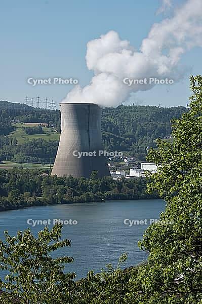 Nuclear power plant in Leibstadt with cooling tower and steam clouds, steam clouds over the nuclear power plant cooling turn, energy generation plant with nuclear power plant, nuclear power plant cooling tower between trees with steam clouds and power pol [IBR124636294]