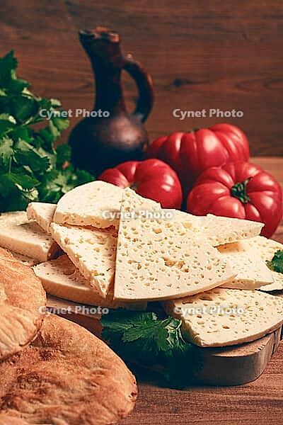 Georgian sliced cheese, on a wooden chopping board, with tomatoes with herbs and lavash, rustic style, Georgian cuisine, no people [IBR124748954]