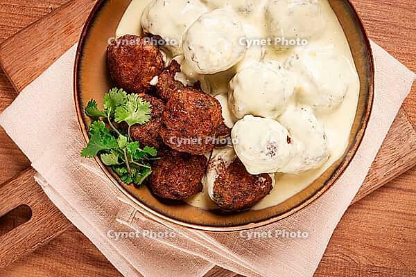 Swedish meatballs in cream sauce, plate on a wooden table, homemade, no people [IBR124748960]