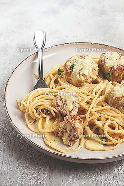 Spaghetti with chicken meatballs, with cream sauce, and parmesan cheese, and decorated with microgreens, homemade, no people [IBR124748975]