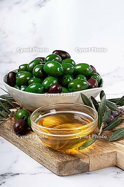 Chalkidiki olives, classic Greek green olives, in a bowl on a cutting board, top view, without people [IBR124748976]
