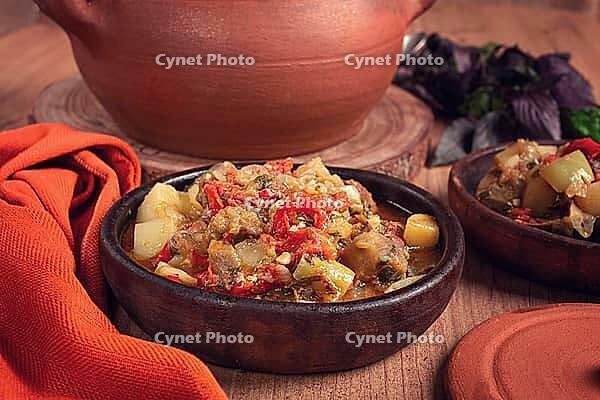 Chanakhi, a Georgian dish. in a clay pot, on a wooden table, stewed meat with vegetables, homemade, no people [IBR124748993]