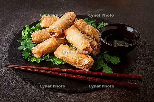 Pork nams, Vietnamese pancakes, rice paper stuffed, on black slate, with gnocchi sauce, no people [IBR124748996]