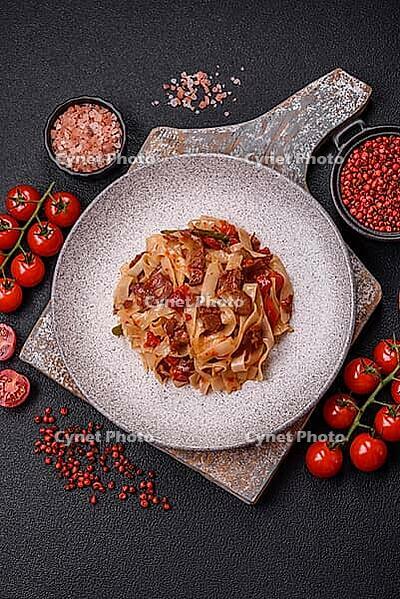 Food, Delicious asian udon dish with vegetables, meat, salt and spices on a ceramic plate on a dark concrete background [IBR124773703]
