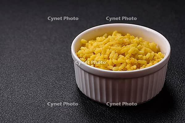Food, Delicious boiled yellow rice with turmeric, salt and spices on a dark concrete background [IBR124773772]