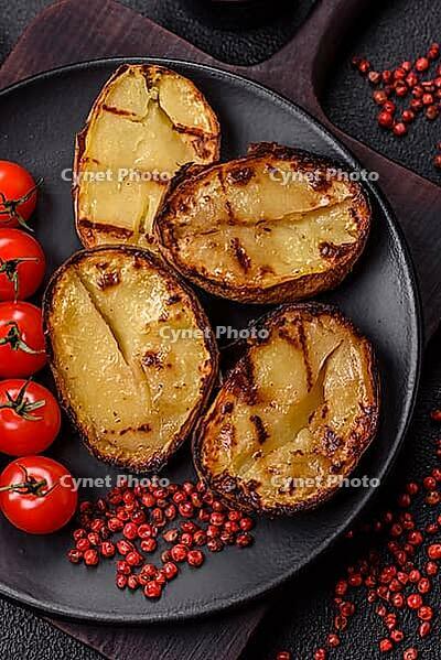 Food, Delicious potato halves in skins baked on the grill with salt, spices and herbs [IBR124773773]