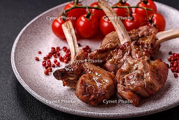 Food, Delicious juicy meat on the bone or rack of lamb or grilled veal with salt, spices and herbs [IBR124773774]