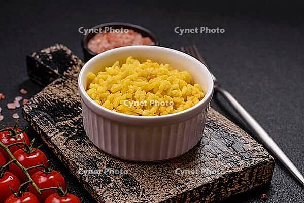 Food, Delicious boiled yellow rice with turmeric, salt and spices on a dark concrete background [IBR124773776]