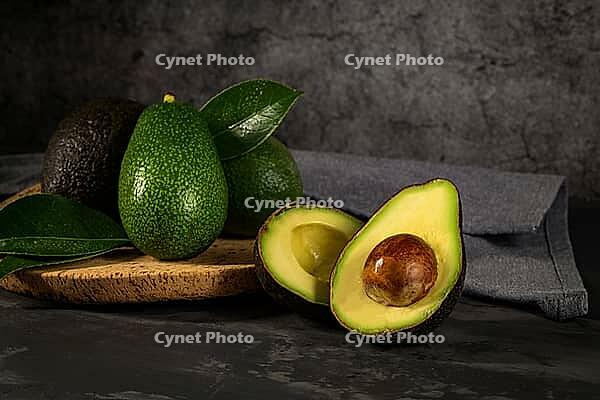 Delicious avocados in a cork plate on kitchen countertop [IBR124817848]