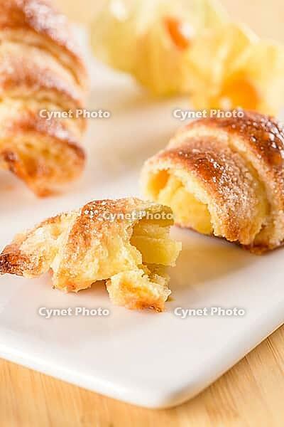 Small croissant with physalis fruits in white ceramic tray, homemade cakes on wooden table top [IBR124817870]