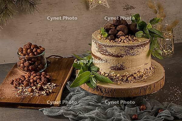 Delicious naked coffee and hazelnuts cake on table rustic wood kitchen countertop [IBR124817896]
