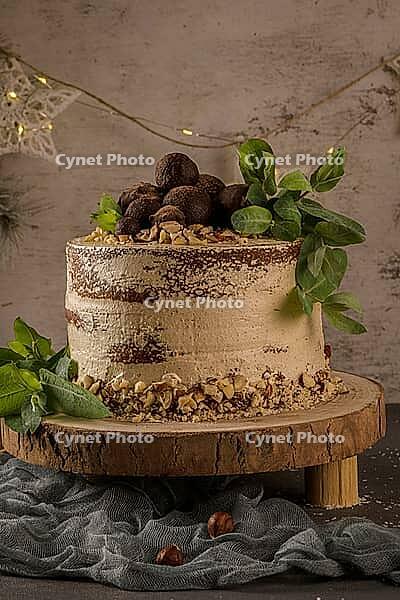 Delicious naked coffee and hazelnuts cake on table rustic wood kitchen countertop [IBR124817899]