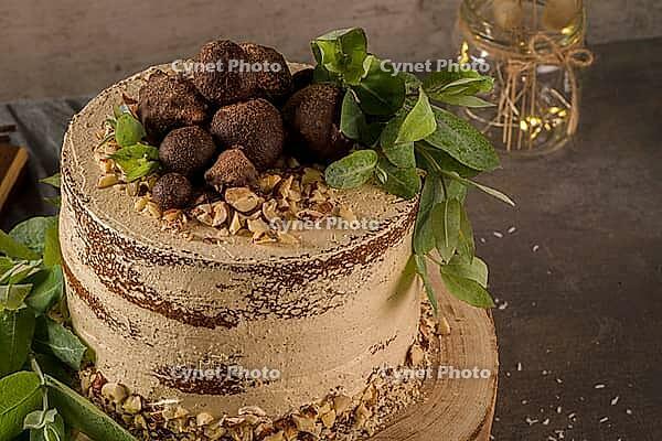 Delicious naked coffee and hazelnuts cake on table rustic wood kitchen countertop [IBR124817900]