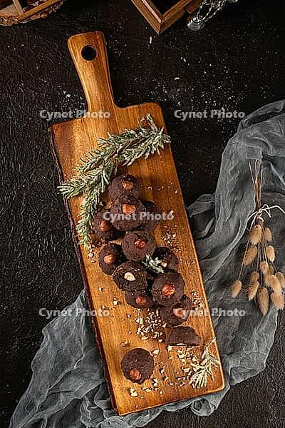 Dark chocolate truffles with hazelnuts over wooden cutting board [IBR124817905]