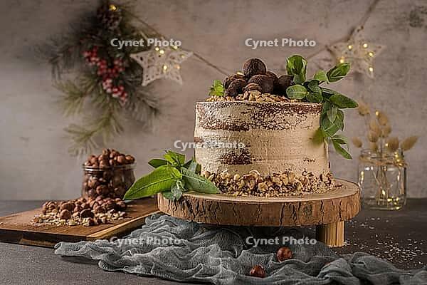 Delicious naked coffee and hazelnuts cake on table rustic wood kitchen countertop [IBR124817907]