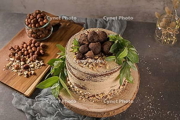 Delicious naked coffee and hazelnuts cake on table rustic wood kitchen countertop [IBR124817916]