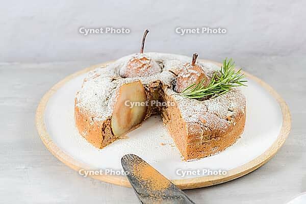 Delicious cake slice with pear, ginger and cinnamon on a plate in a dark kitchen counter [IBR124817927]