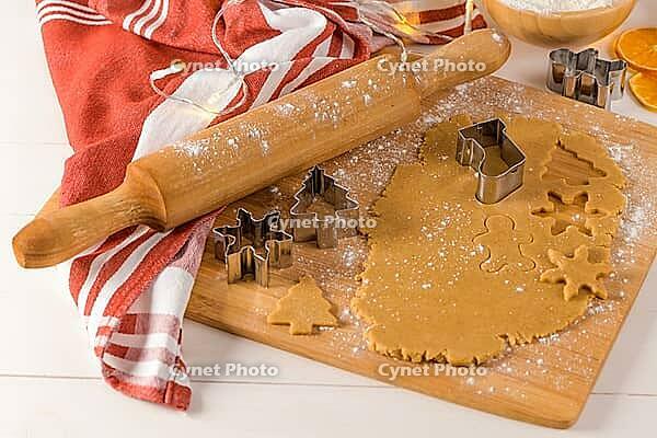 Raw dough for christmas cookies and cookie cutters on kitchen countertop [IBR124817930]