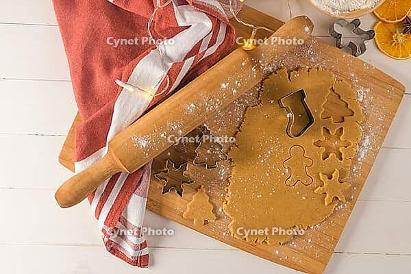 Raw dough for christmas cookies and cookie cutters on kitchen countertop [IBR124817932]