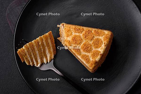 Food, Delicious fresh sweet honey cake layer cake with white cream on textured concrete background [IBR124842052]