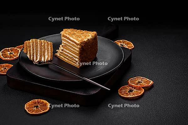 Food, Delicious fresh sweet honey cake layer cake with white cream on textured concrete background [IBR124842055]