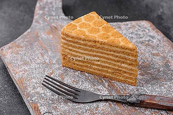 Food, Delicious fresh sweet honey cake layer cake with white cream on textured concrete background [IBR124842058]