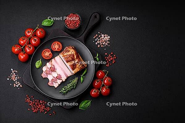 Food, Delicious calorie smoked bacon with salt, spices and herbs on a dark concrete background [IBR124842081]