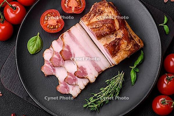 Food, Delicious calorie smoked bacon with salt, spices and herbs on a dark concrete background [IBR124842084]