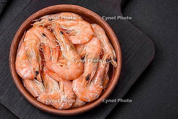 Food, Delicious fresh boiled tiger prawns with salt and spices on a ceramic plate on a dark concrete background [IBR124842105]
