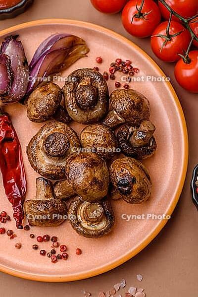 Grilled mushroom pieces, a vegetarian healthy meal with sauce. Barbecue mushroom halves as a food backdrop for your design [IBR124865232]