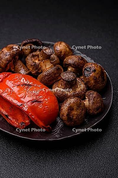 Grilled mushroom pieces, a vegetarian healthy meal with sauce. Barbecue mushroom halves as a food backdrop for your design [IBR124865237]